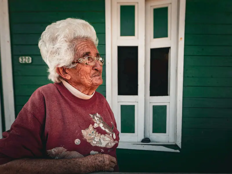 A resident in a red sweater on the front porch, waiting for the cat