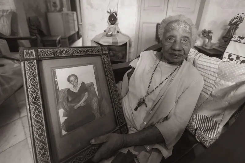 A resident holding a framed portrait of her younger self