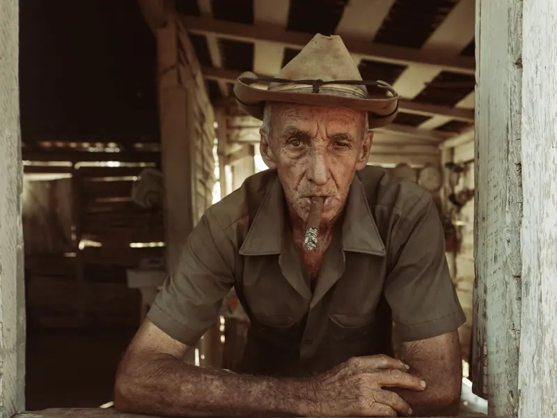 A farmer leaning on a workbench in the barn