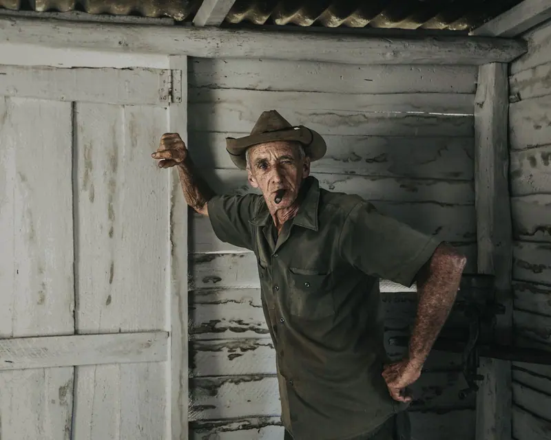 A farmer in his cap at the barn door
