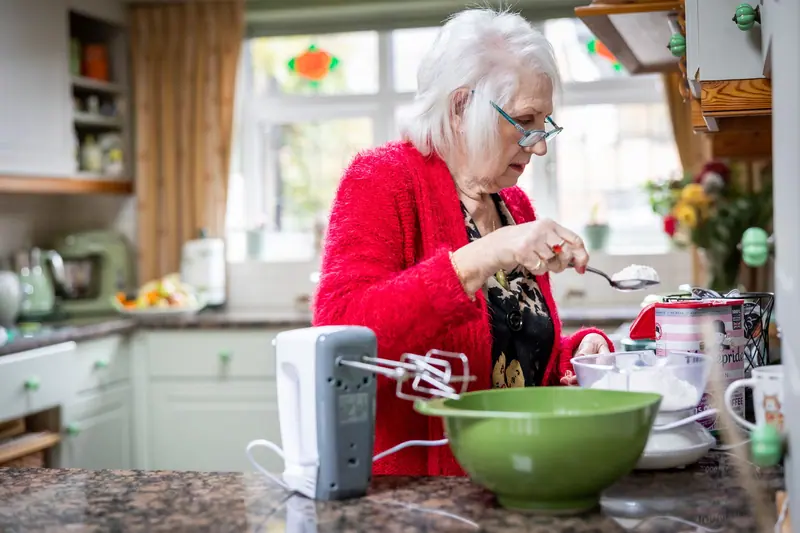 A resident stirring batter in the bright kitchen
