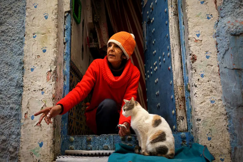 A resident in an orange sweater pointing out something to her cat