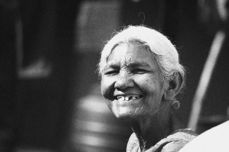 Black-and-white portrait of a resident with white hair, laughing