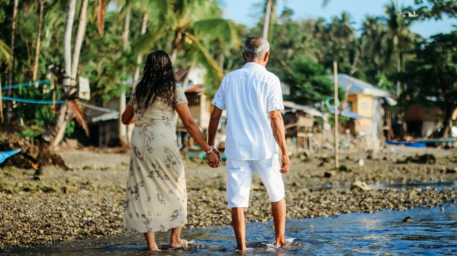 A couple walking hand in hand through the shallows