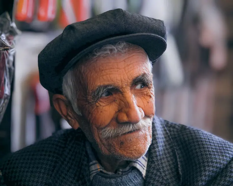 Portrait of a resident in a flat cap and tweed jacket