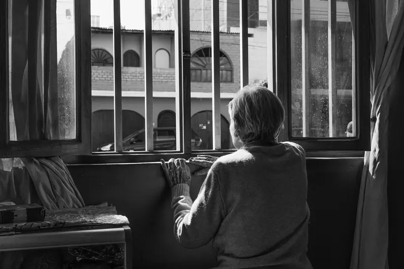 A resident at the tall window in black and white