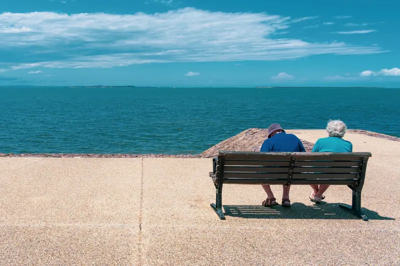 A couple on a bench at the edge of the turquoise water