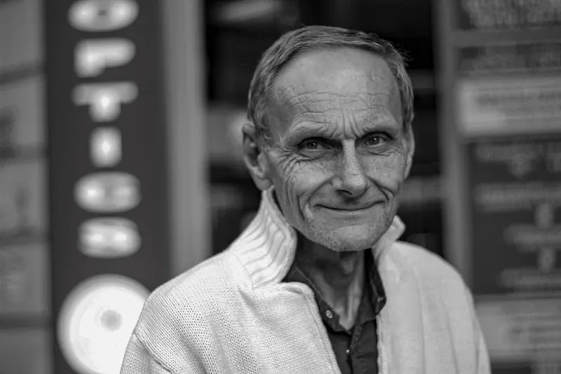 Black-and-white portrait of a resident in a cardigan, smiling softly
