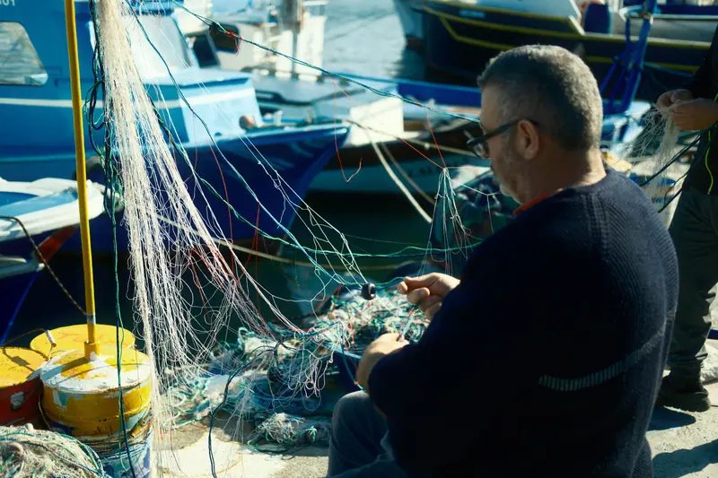 A resident mending a fishing net