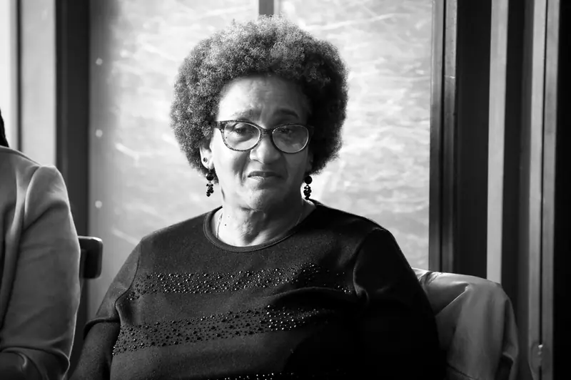 Black-and-white portrait of a resident in glasses by the window