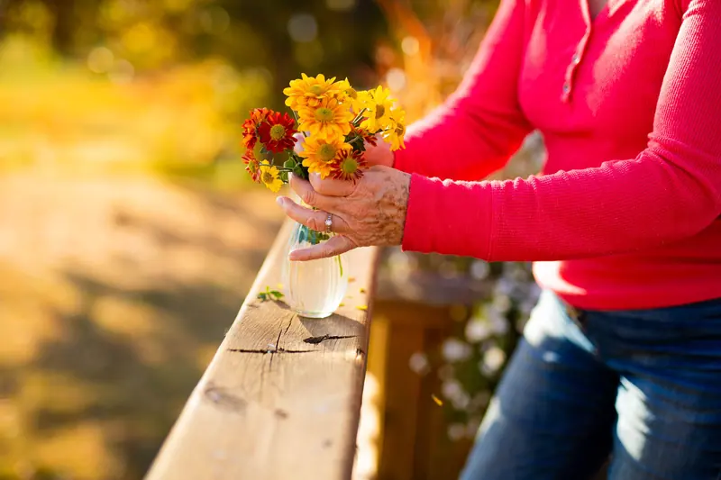 Fresh flowers from the garden in a jar on the porch rail