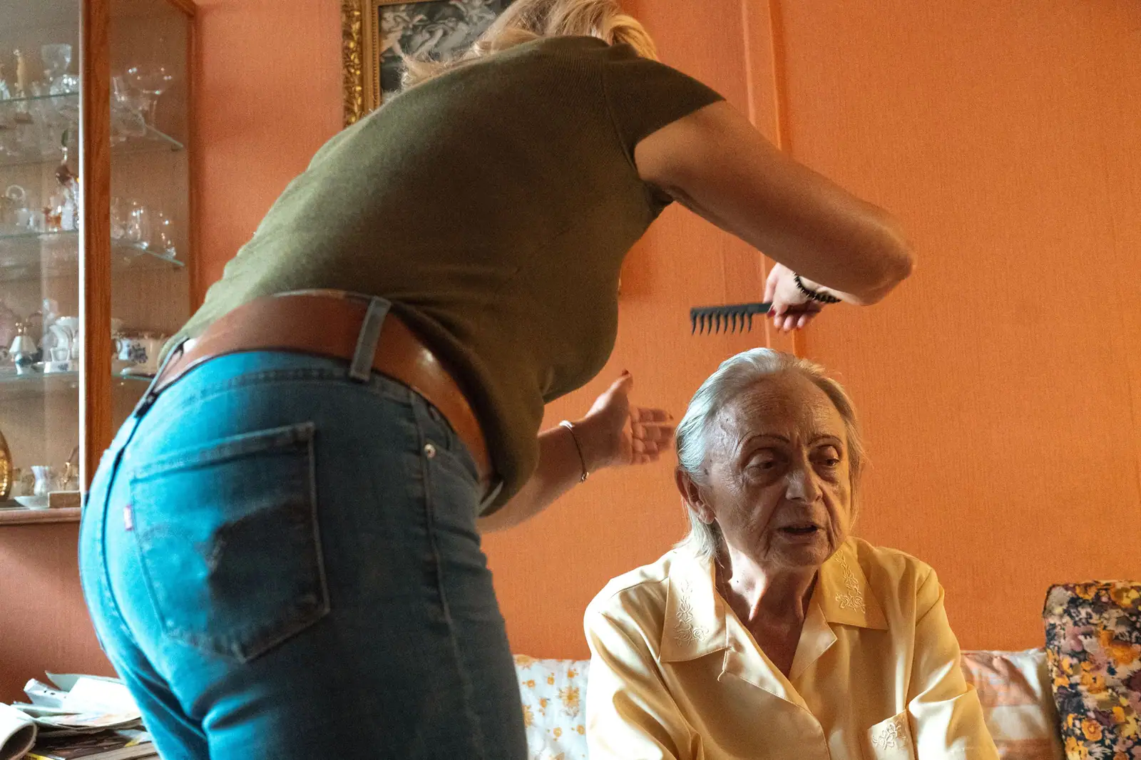 A caregiver assisting an elderly woman in grooming at home.