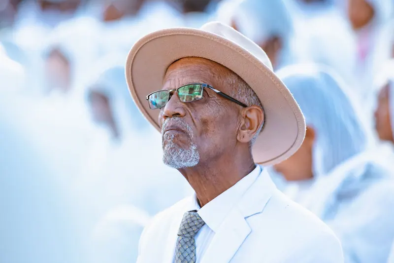 A resident in a white suit and straw hat