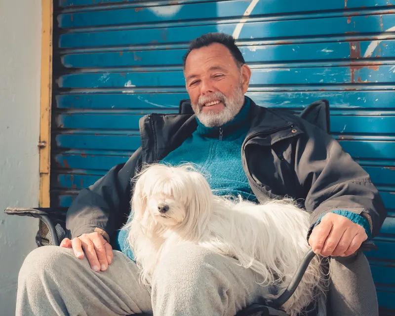 A resident with a fluffy white dog on his lap