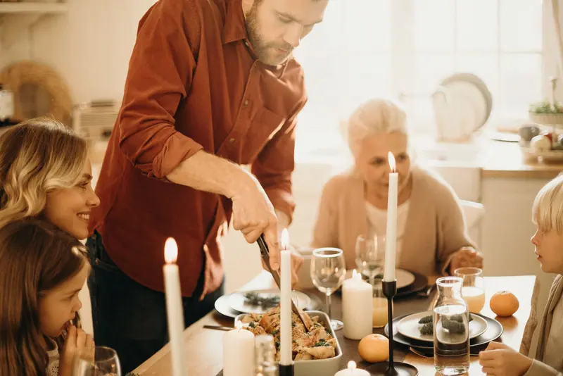 A son carving the turkey for his mother