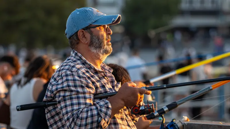 A resident in a blue cap casting in the evening light