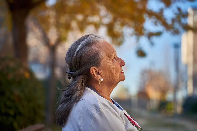 A resident looking up into the autumn trees