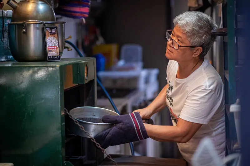 A resident lifting a pan from the oven