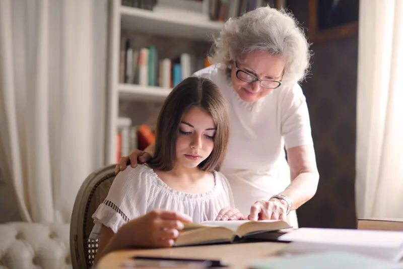 A resident reading aloud with a young visitor