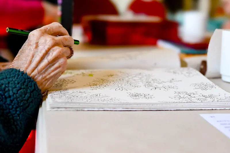A resident's hand coloring a detailed pattern