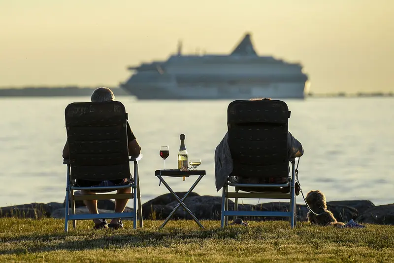 Two deck chairs and a bottle of wine at sunset