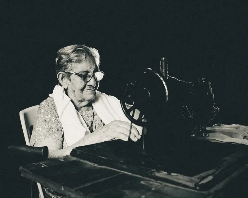Black-and-white portrait of a resident at her sewing machine