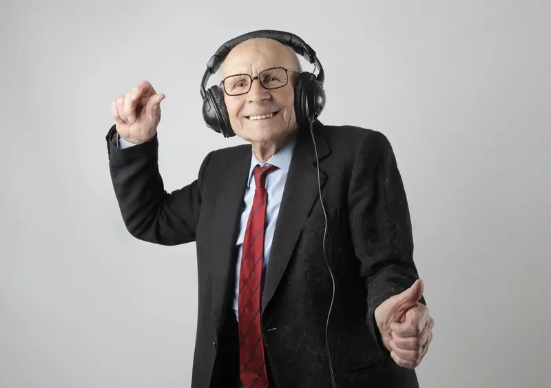 A resident in a suit and red tie dancing to his playlist