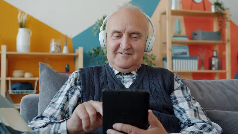 A resident choosing a song on his tablet in the living room