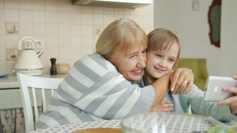 A resident and a girl sharing a laugh over a phone video