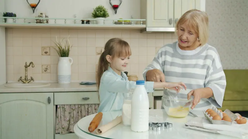 A resident baking with her granddaughter in the kitchen