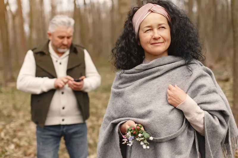 A resident wrapped in a gray shawl on a fall walk
