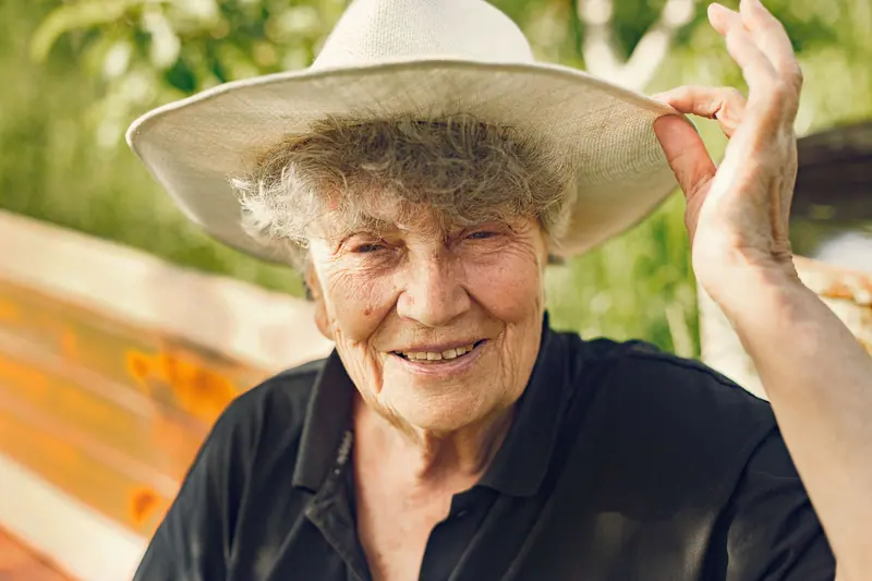 A resident in a straw hat smiling in the April sun