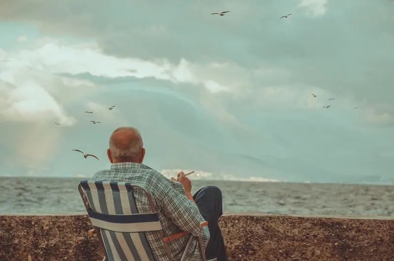 A resident in a lawn chair watching the water and the gulls