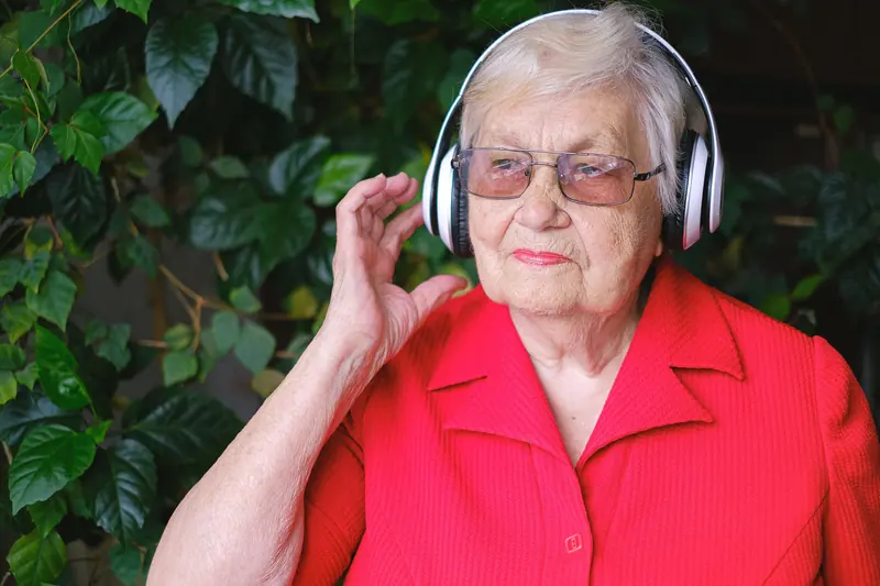 A resident in red listening to music in the courtyard
