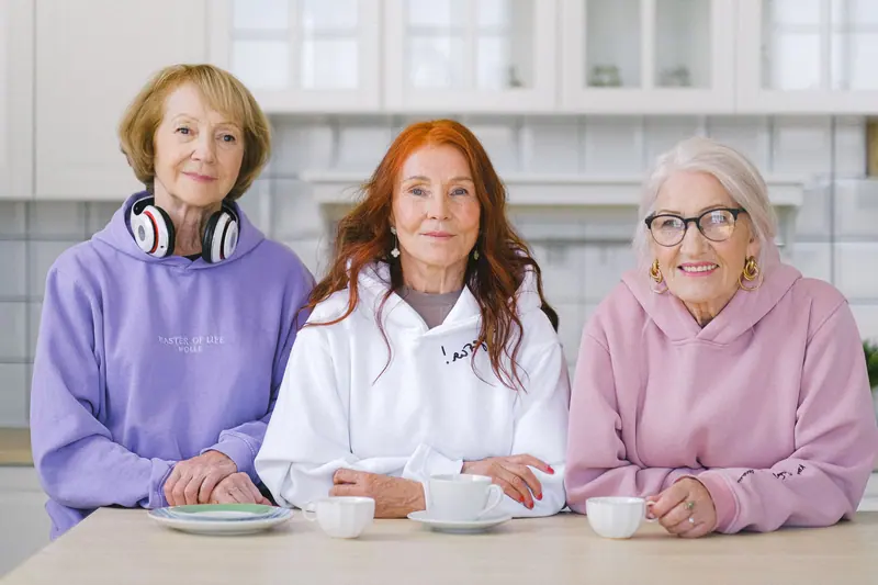Three residents sharing coffee at the kitchen table