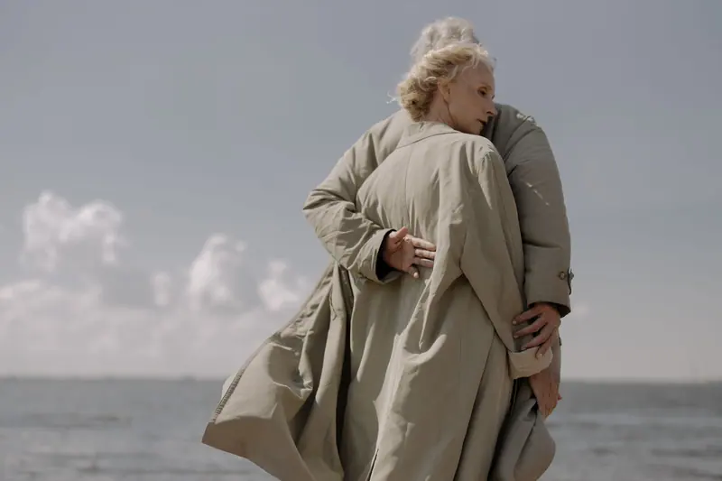 A couple embracing on the windy shore