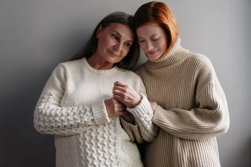 A resident and her daughter sitting close together in the parlor