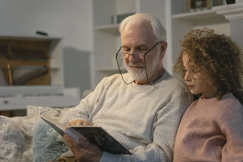 A resident reading with his granddaughter