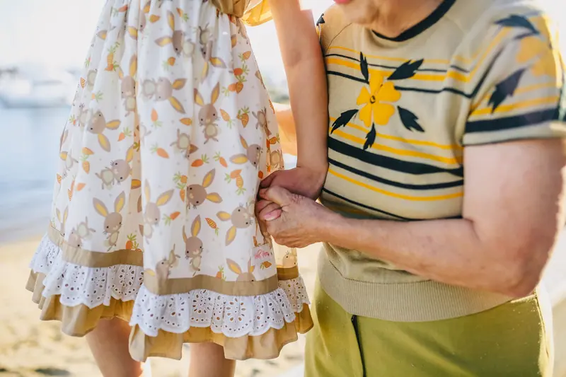 A resident holding a small hand on the courtyard walk