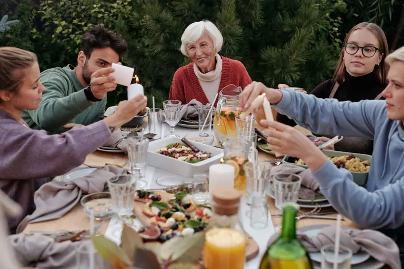 Three generations raising glasses at the garden table