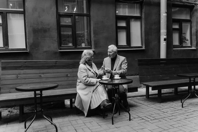 Black-and-white photograph of a couple at a courtyard table