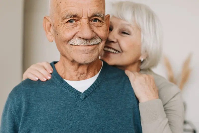 A resident's wife hugging him from behind