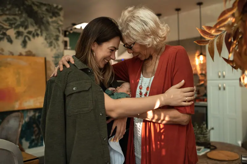 A resident hugging her granddaughter in the front hall