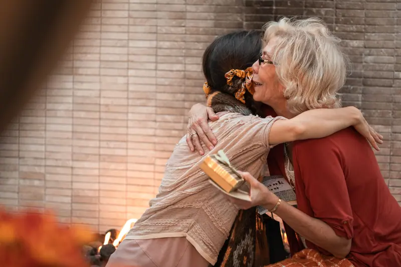 A resident hugging a visitor who brought her a gift