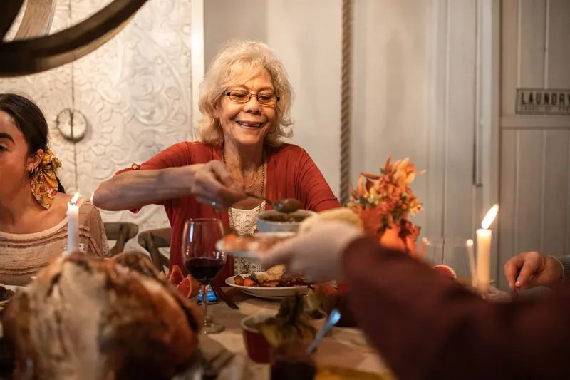 A resident passing dishes at the family dinner