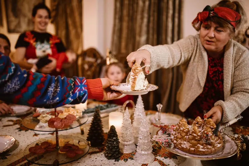 A resident serving cake at the Christmas table