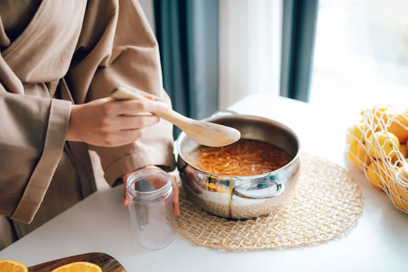 Stirring orange marmalade on the stove