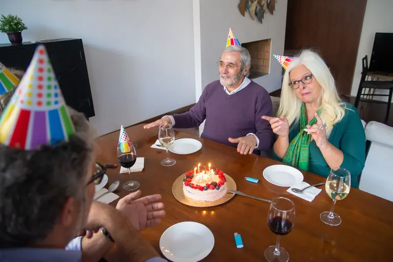 A couple's birthday supper with a cake and party hats