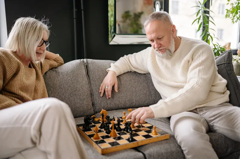 A couple playing chess on the sofa