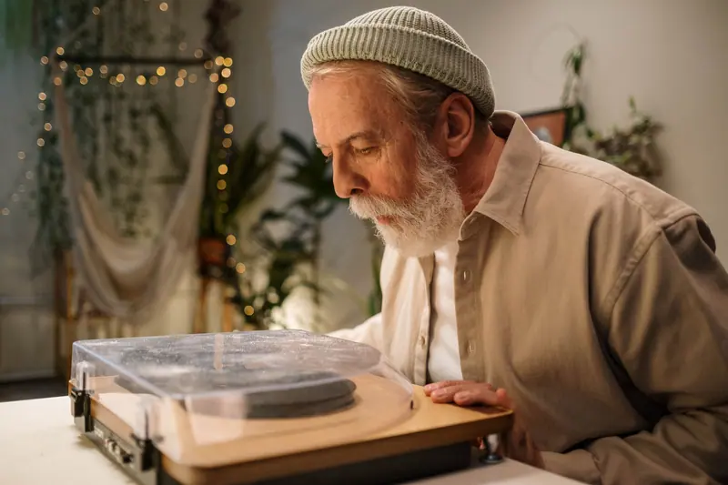 A resident in a knit cap studying the turntable before supper club
